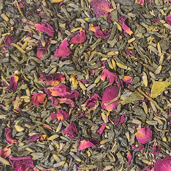 A close up of the Unrelenting Love blend - vibrant green tea leaves interspersed with blue-green lavender petals and bright violet rose petals