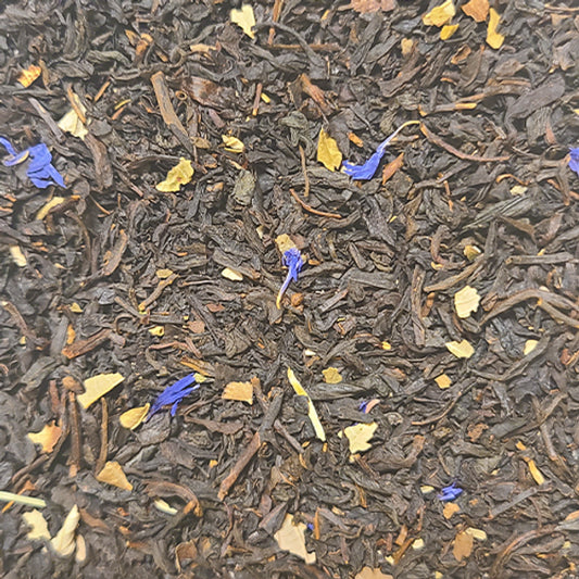 A close up of the Belonging tea blend - cornflower flowers and black currant leaves on a bed of vibrant black tea leaves