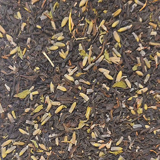 A close up of the Certainty blend - lavender petals and spearmint leaves on a bed of black tea leaves