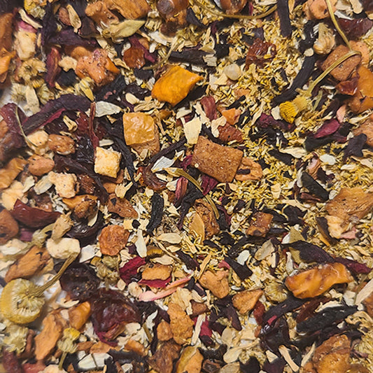 A close-up of the "Repose" tea blend - a mixture of dried fruit pieces, chamomile flowers, and hibiscus petals